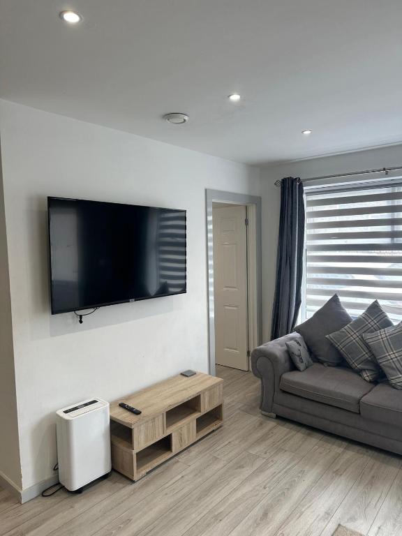 un soggiorno con divano e TV a schermo piatto di Noahs Corner a Milford Haven