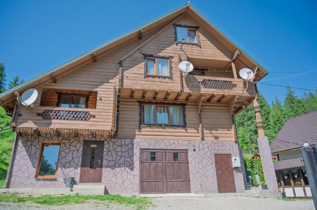 a wooden house with a gambrel roof at Апартаменти у Яни in Yablunytsya