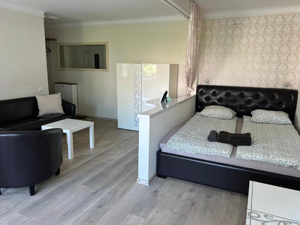 a bedroom with a bed and a living room at Danės 5 apartament in Klaipėda