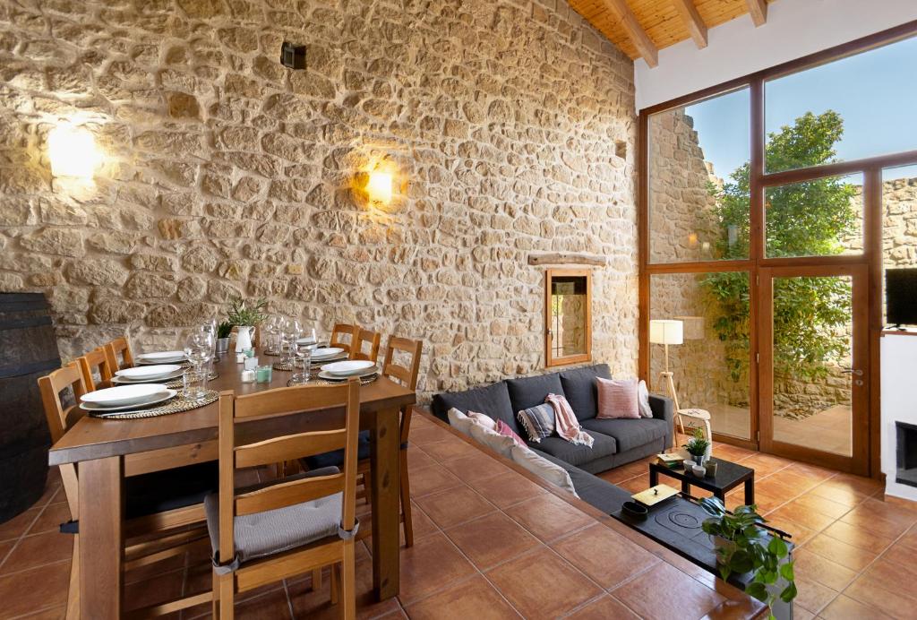 un soggiorno con un tavolo e un divano di Espacioso pajar con barbacoa - Casa de las Letras a Lledó