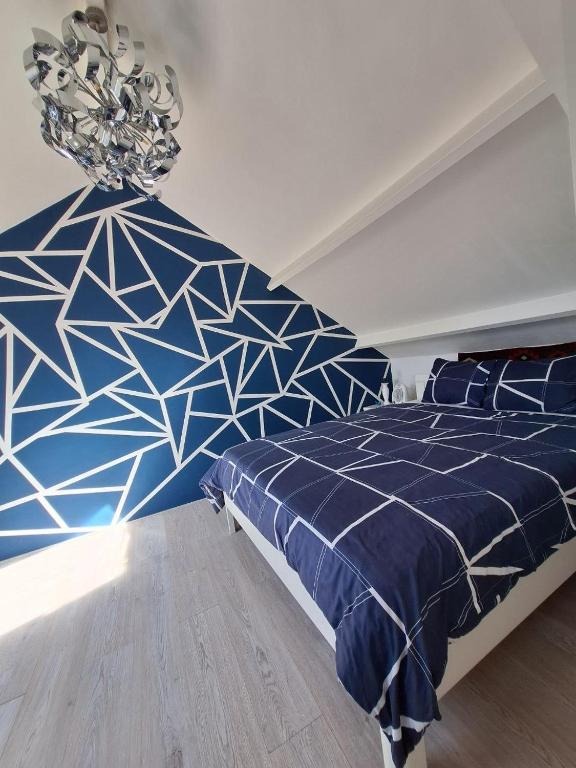 a bedroom with a blue bed and a chandelier at Cozy Nest in Deventer