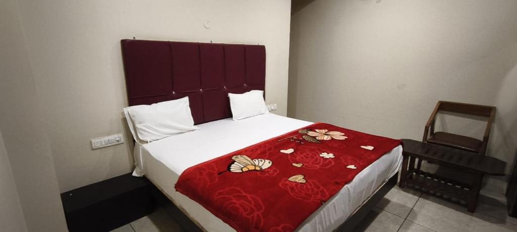 a bedroom with a large bed with a red blanket at Hotelringas in Dewās