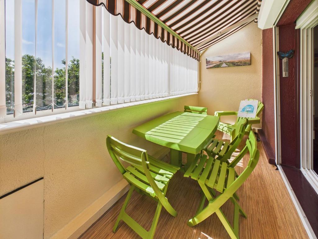 d'une table verte et de deux chaises sur le balcon. dans l'établissement 550m de la plage au centre d'Andernos - pour 4, à Andernos-les-Bains