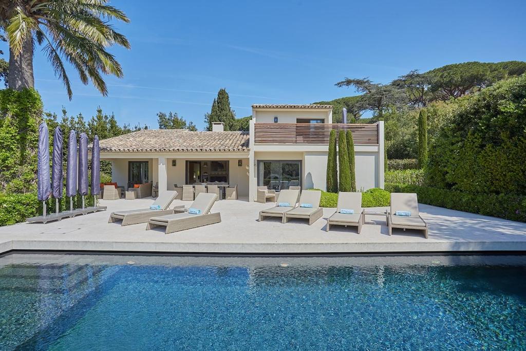 une maison avec une piscine devant une maison dans l'établissement Villa Fortune, Saint-Tropez, à Saint-Tropez