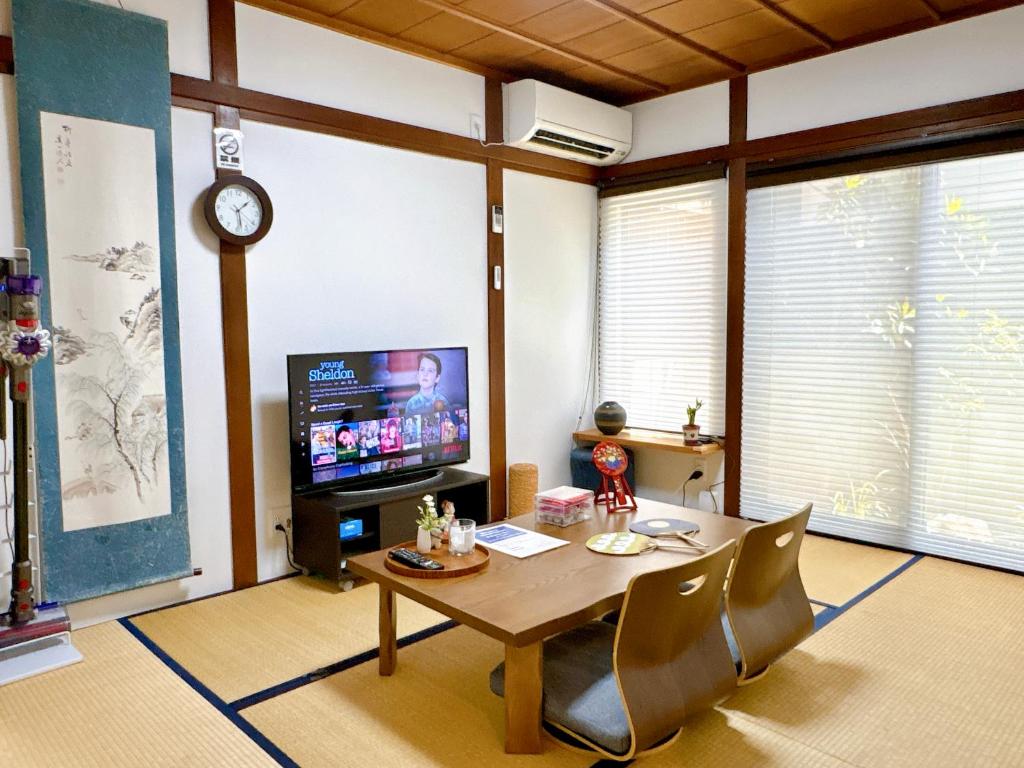 Hotel Tofukuji Saku Inn（东福寺咲く宿）, a living room with a table and a tv at Tofukuji Saku Inn（东福寺咲く宿） in Kyoto