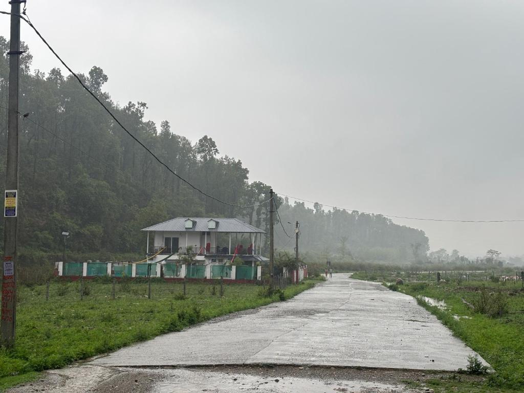 a road with a house on the side of it at Mountain Valley in Jhājra