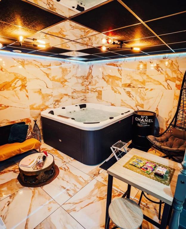 une salle de spa avec une baignoire et une table dans l'établissement Ô Saphir Spa - Maison N2, à Denain
