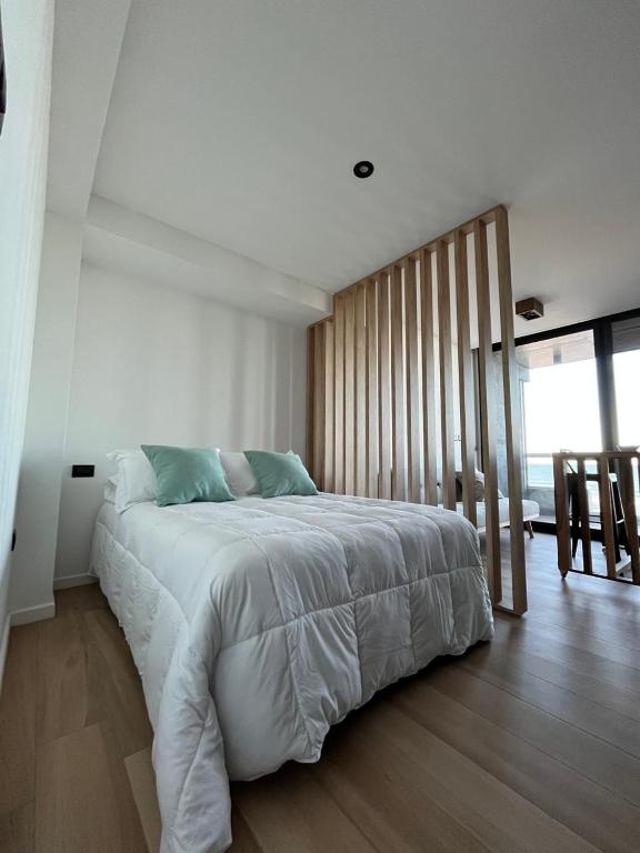 a bedroom with a large bed and a large window at Ammonite Playa in Mar del Plata