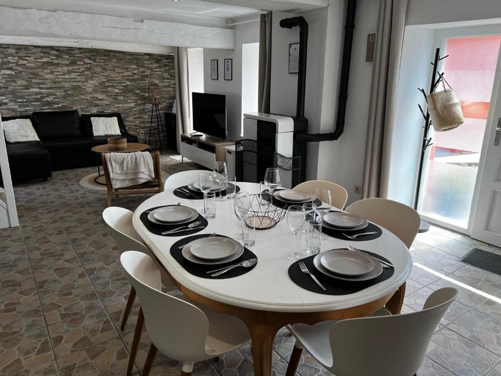 een eetkamer met een witte tafel en stoelen bij Gîte Rubis - JACUZZI - Pairi Daiza - 6 pers in Brugelette