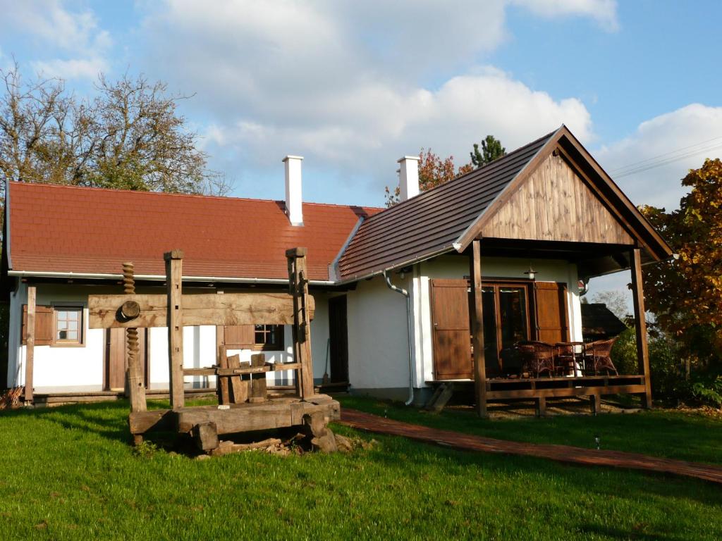 ein kleines Haus mit einer Veranda und einem Tisch in der Unterkunft Őrségi Porta in Magyarszombatfa