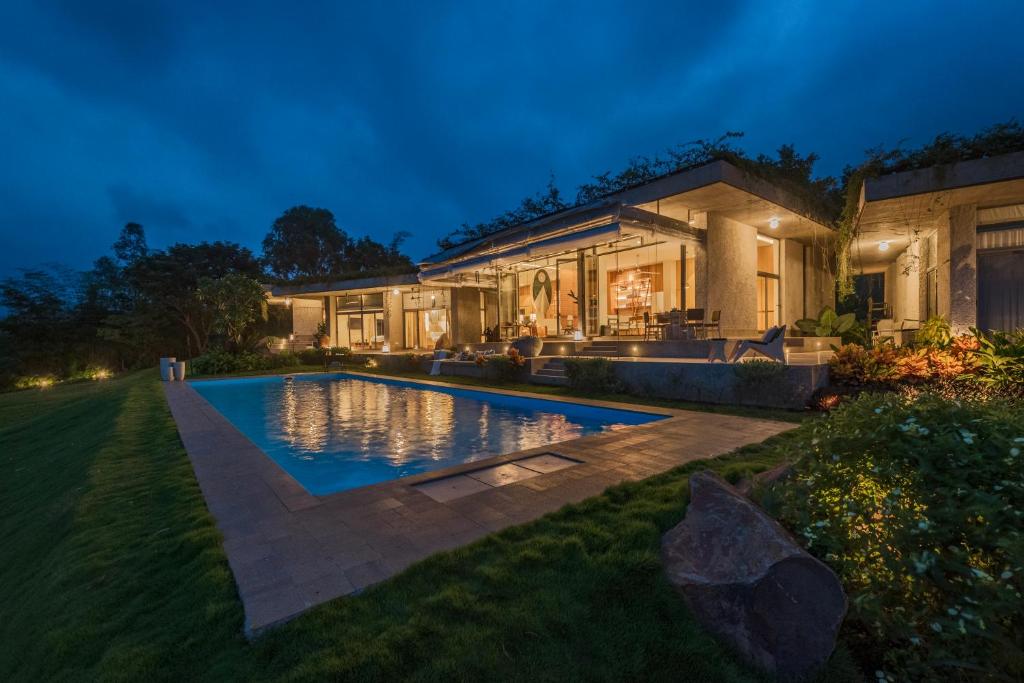 a house with a swimming pool in the yard at SaffronStays Swallow's Nest in Kolvan