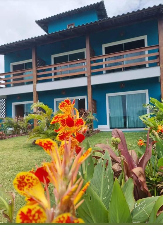 a blue house with flowers in front of it at Pousada Atlantik-Haus in Costa Dourada