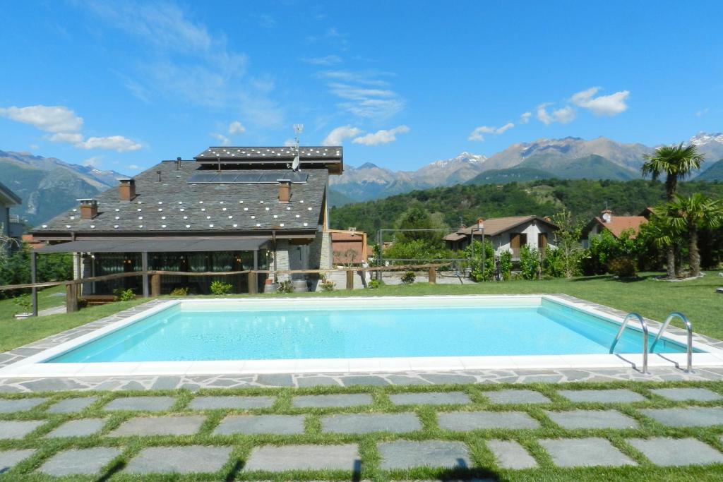 a swimming pool in front of a house at Villa La Corte with amazing pool and garden in Colico