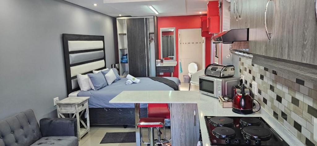 a small room with a bed and a kitchen at Sanctuary Lodge & Day Spa in Pietermaritzburg
