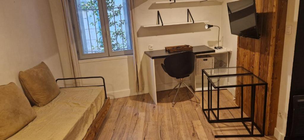 un salon avec un canapé, une table et une télévision dans l'établissement Studio meublé Ecusson - Comédie et gare à pied !, à Montpellier