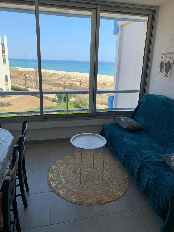 - un salon avec un canapé, une table et des fenêtres dans l'établissement Appartement vue mer 