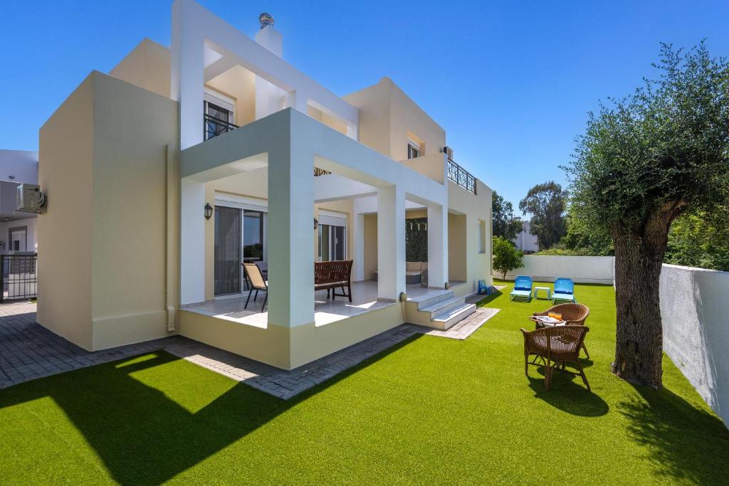 a house with a yard with green grass at Euphoria Villa up to 5 in Ialysos