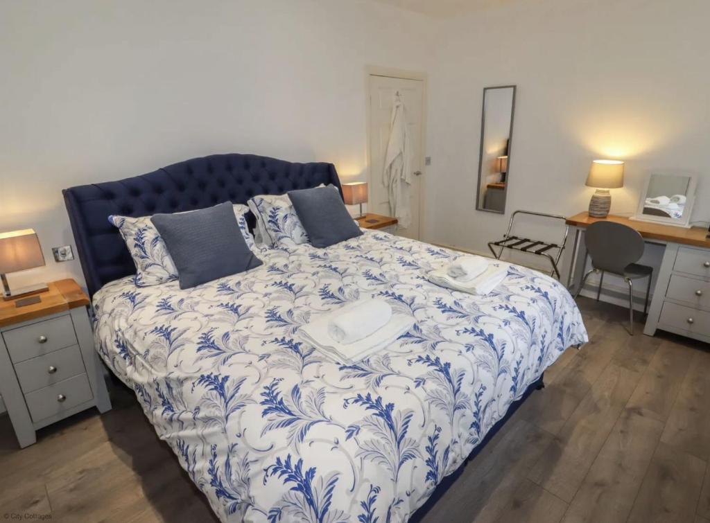 a bedroom with a bed with a blue and white comforter at 4B City Cottages in Chester