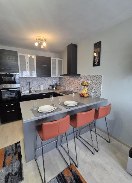 a kitchen with a large island with red chairs at D&D Studio Apartment in Velika Gorica