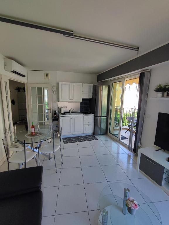 un salon avec une table et une cuisine dans l'établissement Maison de la promenade, à Menton