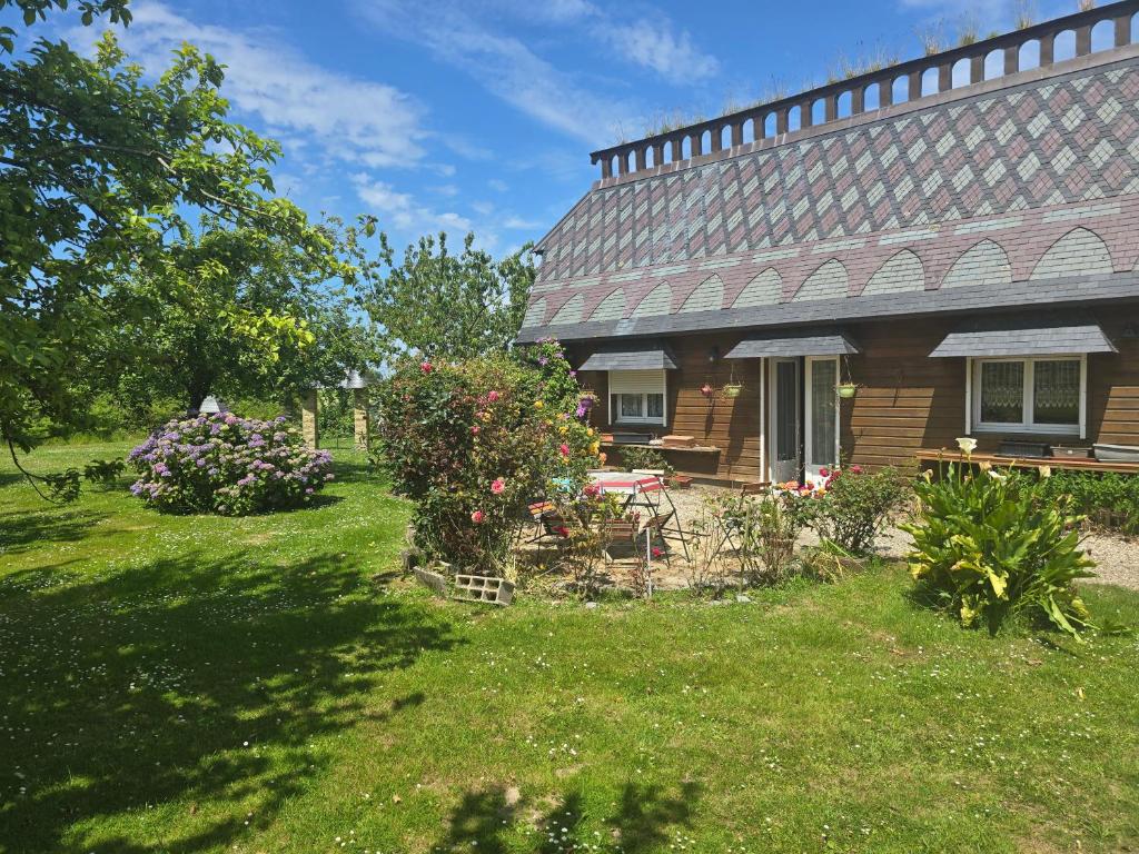 une maison avec une cour ornée de fleurs et de plantes dans l'établissement Cher bene, à Thérouldeville