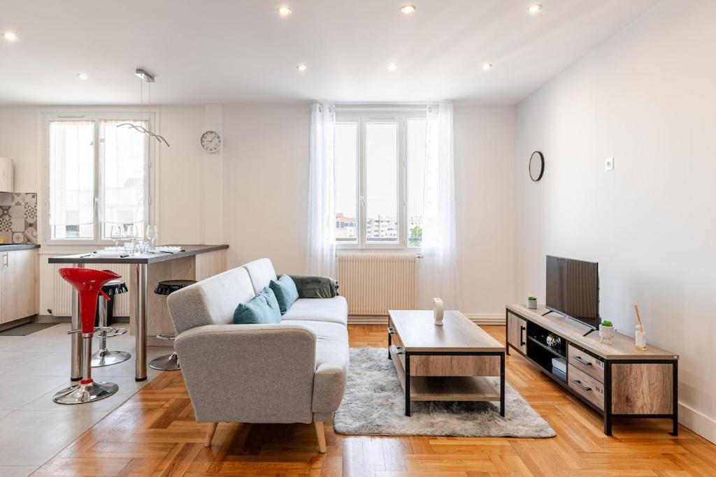un salon avec un canapé et une table dans l'établissement Sublime Appartement Villeurbanne, à Villeurbanne