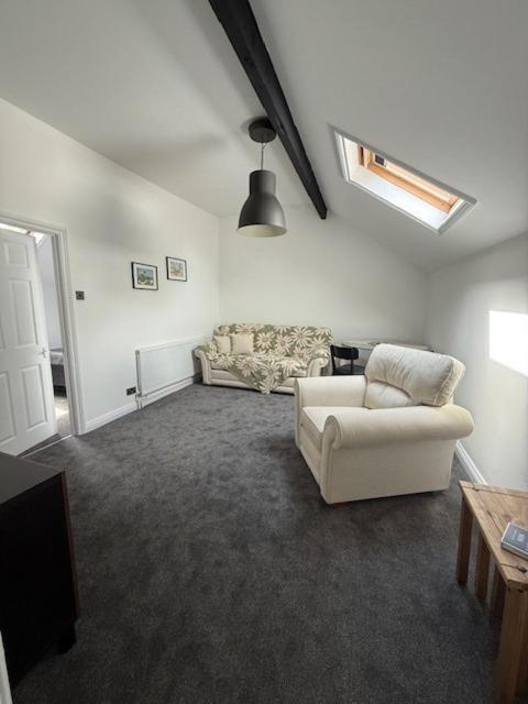 a living room with a couch and a chair at Room above the Inn in Bristol