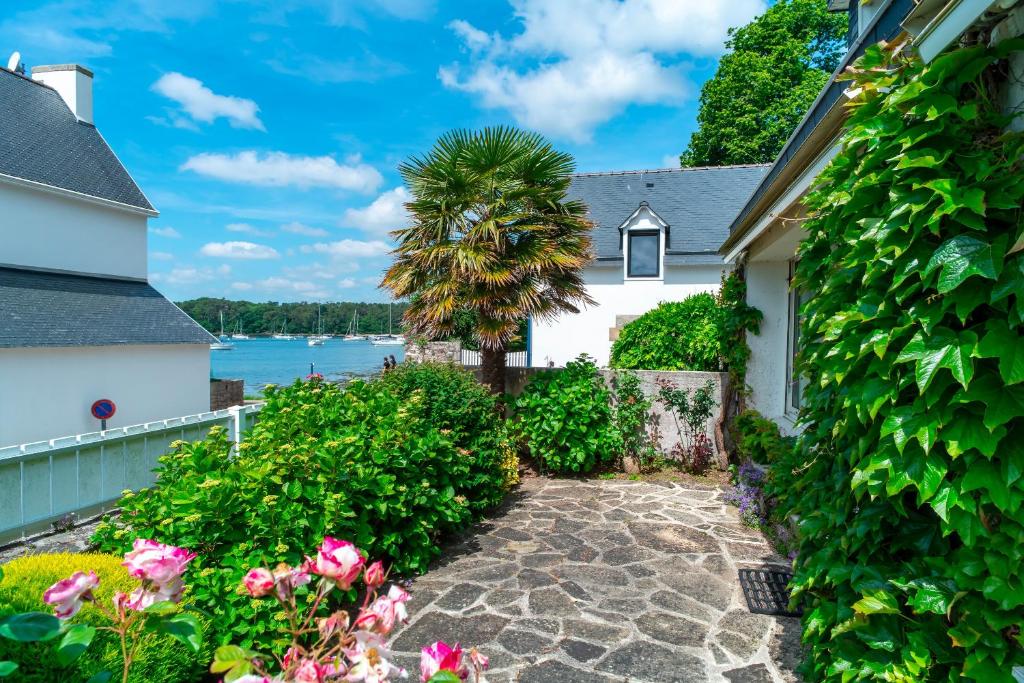 a house with a palm tree and a driveway at Gwell Ar Ster - Maison à 400 m de la plage in Bénodet