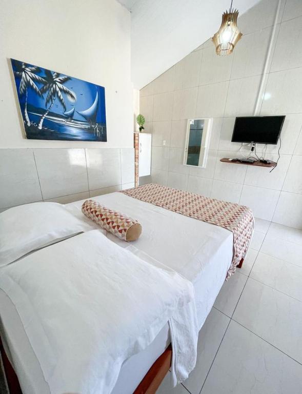 a bedroom with two beds and a tv in it at Pousada o Èdio in Beberibe