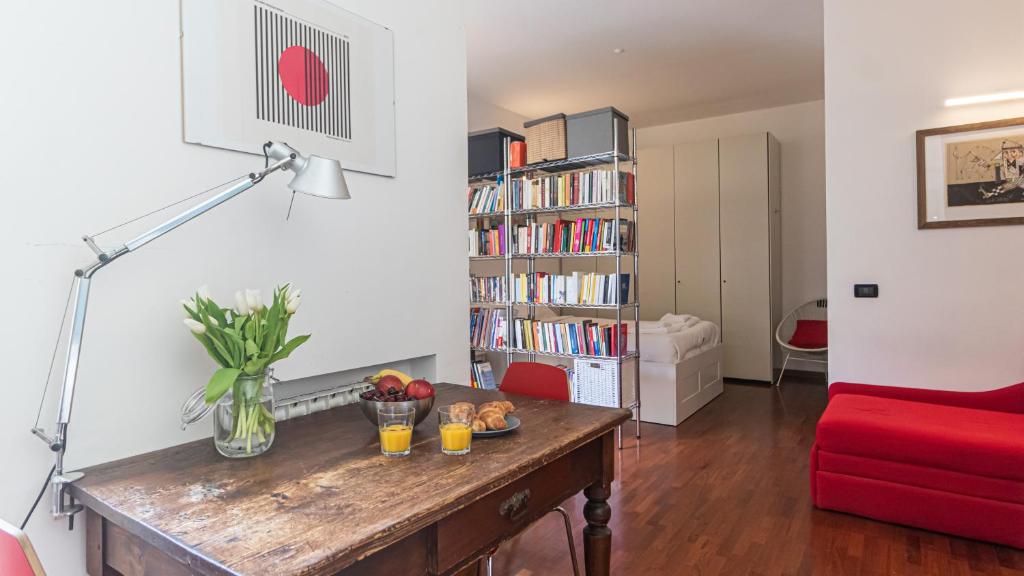 a living room with a table and a red couch at Italianway - Tadino 1 A in Milan