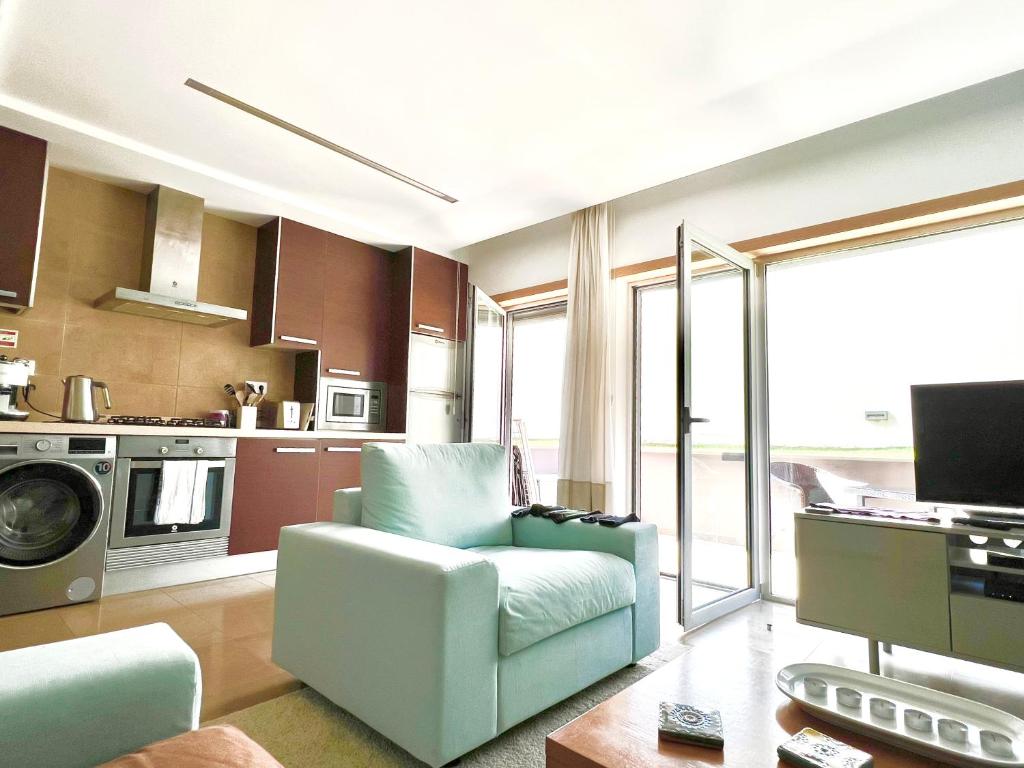 a living room with a couch and a kitchen at 1 Bed Boutique-style Apartment in São Martinho do Porto