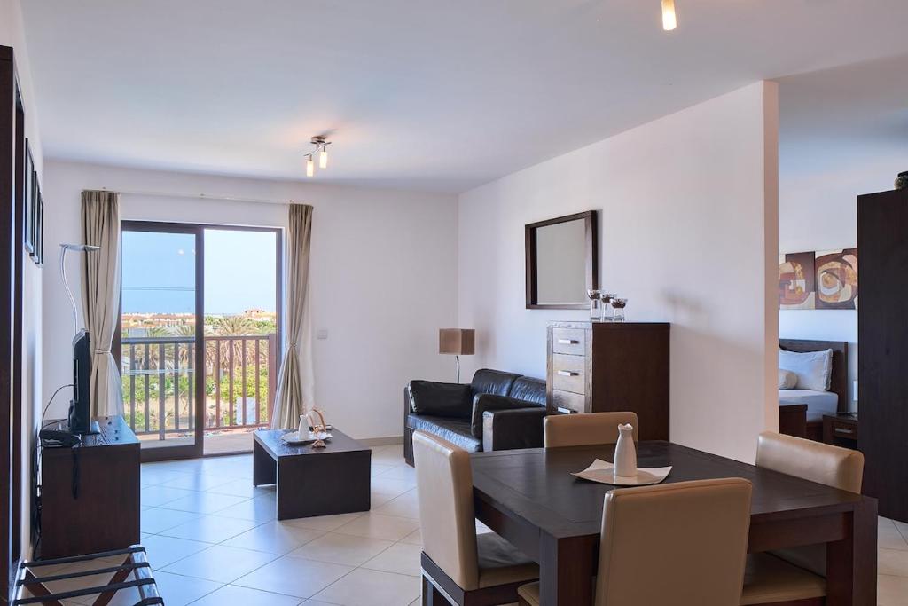 Elegant 1-Bedroom Duplex Apartment في سانتا ماريا: غرفة معيشة مع أريكة وطاولة طعام