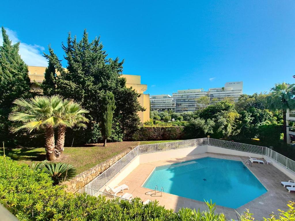 une piscine dans une cour avec un palmier dans l'établissement L'Écrin de la Rostagne, à Antibes