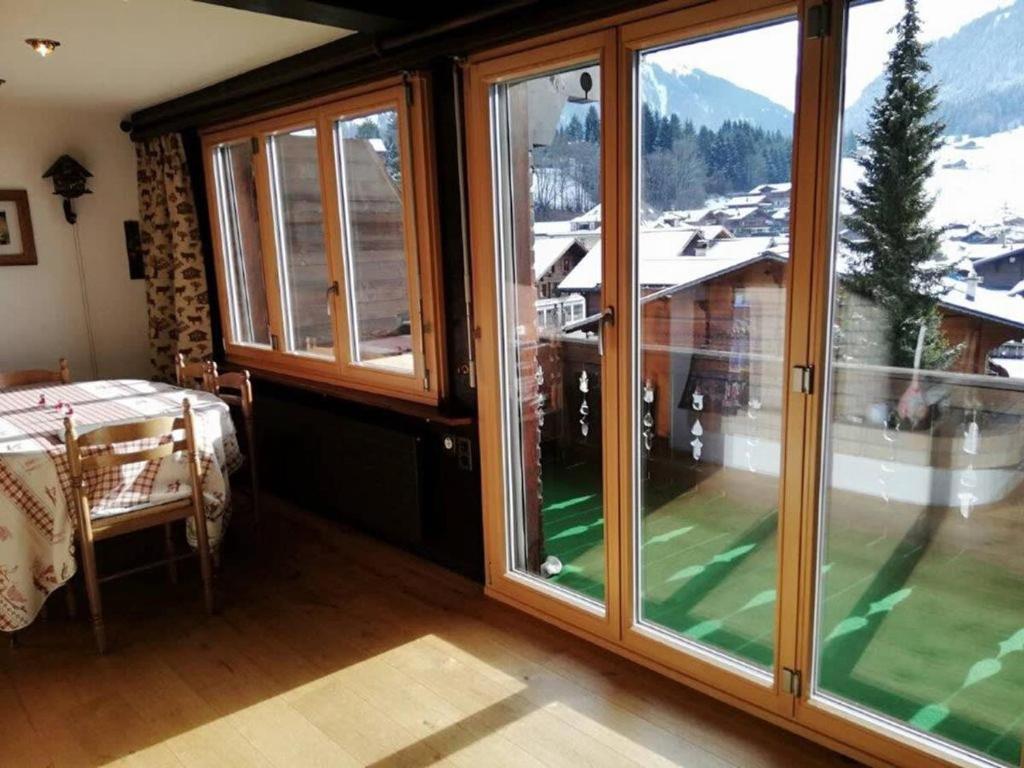 a room with large windows with a view of a mountain at Central Location Cozy 3 BR Flat in Gstaad in Gstaad