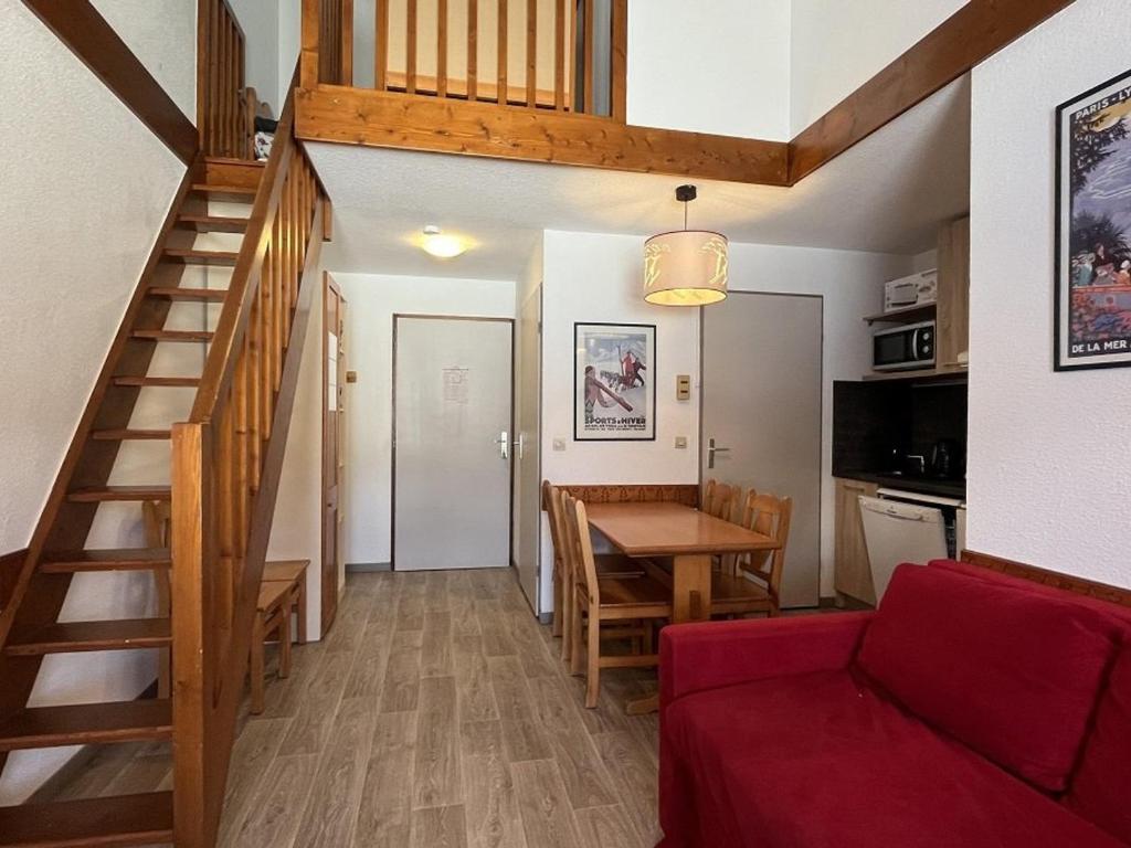 - un salon avec un canapé rouge et un escalier dans l'établissement Appartement 3 pièces, balcon, au pied des pistes, Plagne Soleil - FR-1-351-187, à La Plagne Tarentaise