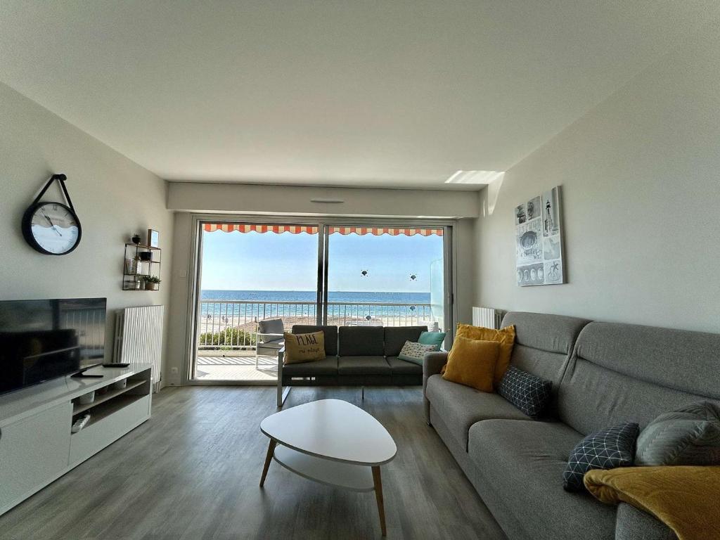 un salon avec un canapé et une vue sur l'océan dans l'établissement Confortable T3, 6 couchages, terrasse et parking - Quartier Benoît, La Baule - FR-1-245-152, à La Baule