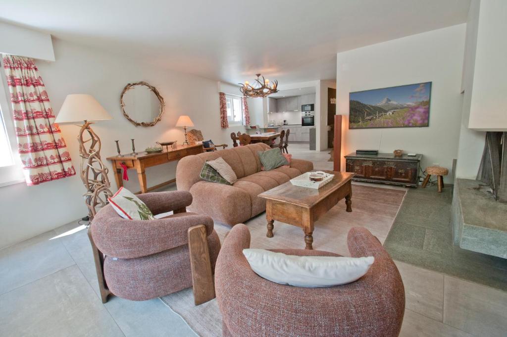 a living room with couches and chairs and a table at La Villa Emeline - Apartment Emilie in Zermatt
