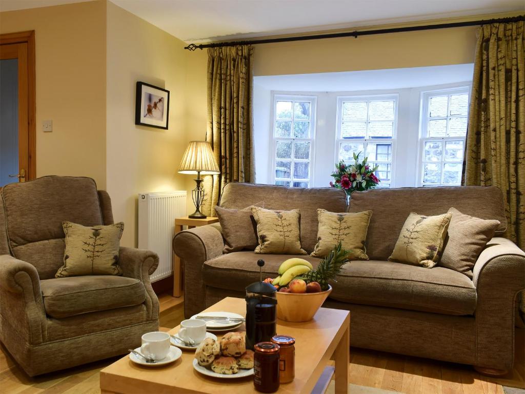 a living room with a couch and a table at Inn Cottage in Glendevon
