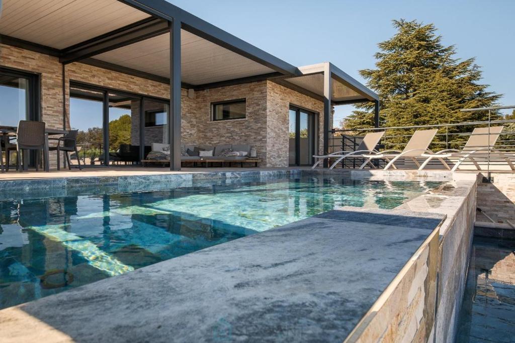 une piscine devant une maison dans l'établissement Villa Baverde Luxury, à Istres