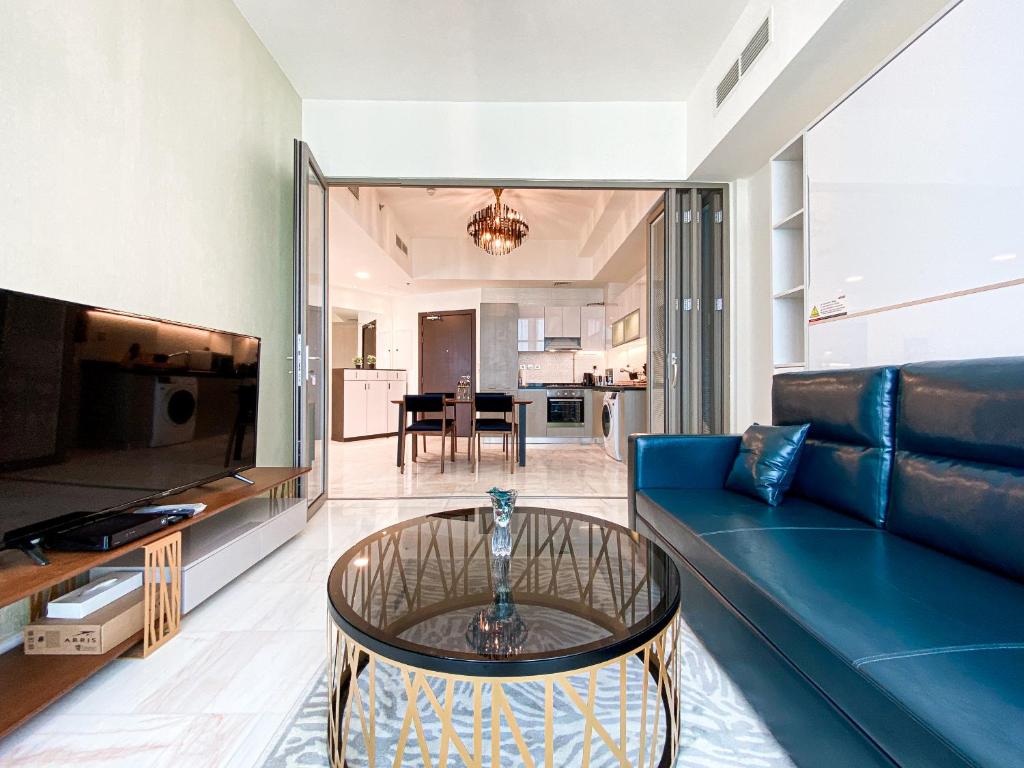 a living room with a blue couch and a glass table at Stylish 1-Bedroom-Sleeps 4- Apartment -Bayz by Danube, Business Bay-29 in Dubai