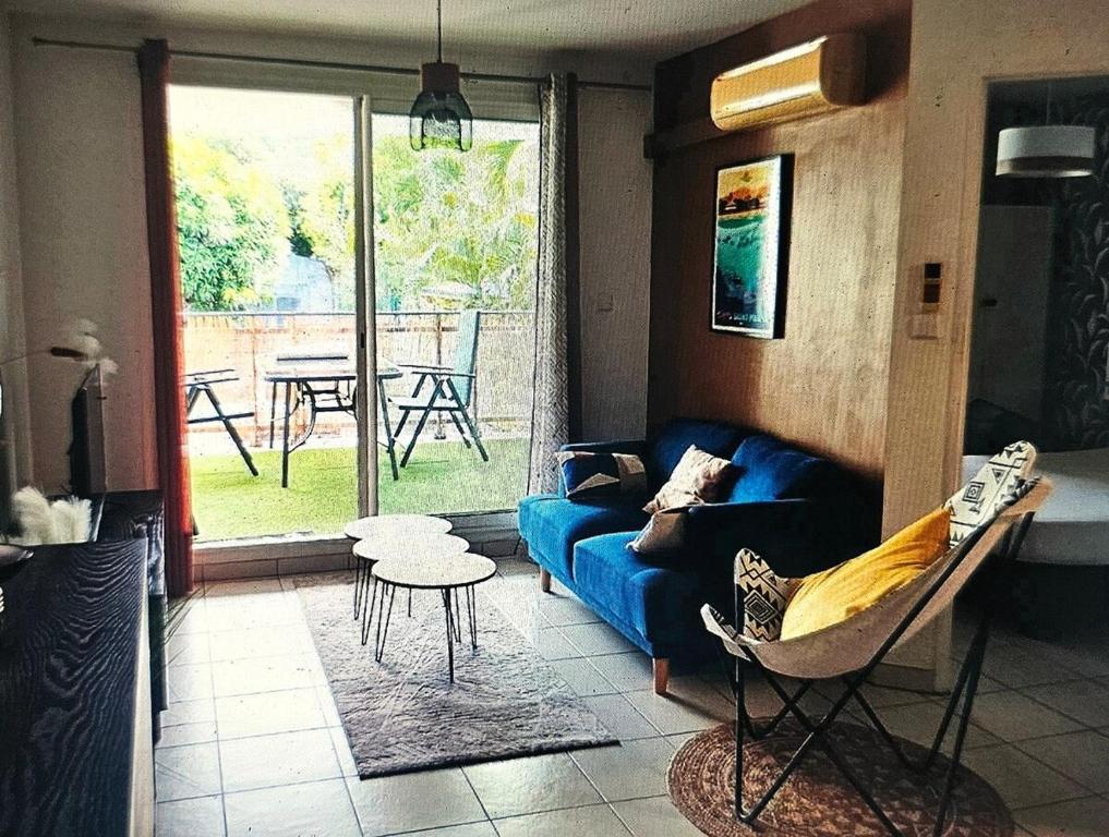 Una sala de estar con un sofá azul y una mesa. en K A Z - Les flamboyants, en Saint-Denis