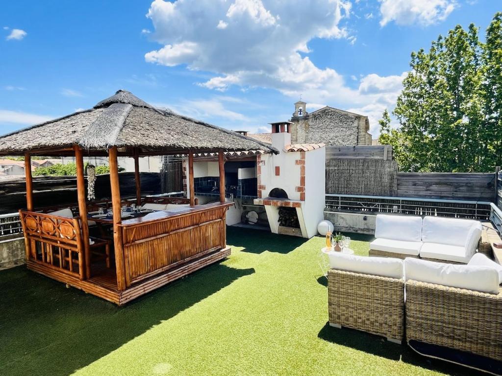 une terrasse avec un kiosque et des chaises sur la pelouse. dans l'établissement Appartement d'exception avec jacuzzi 160m2, à Pertuis