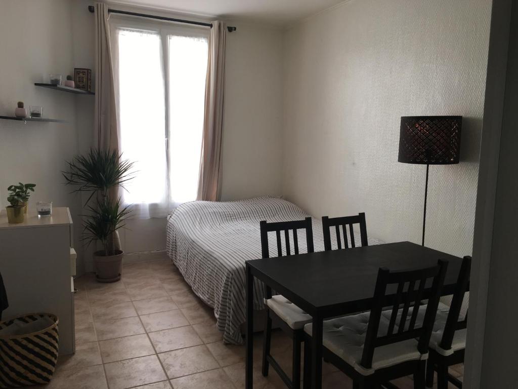 - une chambre avec une table, un lit et une fenêtre dans l'établissement Studio à 2 pas du métro, à Paris