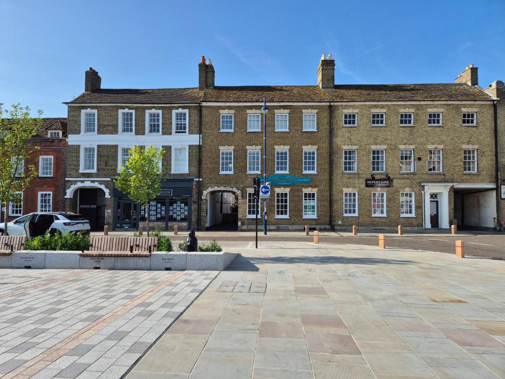 a large brick building with benches in front of it at Stunning & spacious Georgian town house in St Neots town centre with parking in Saint Neots