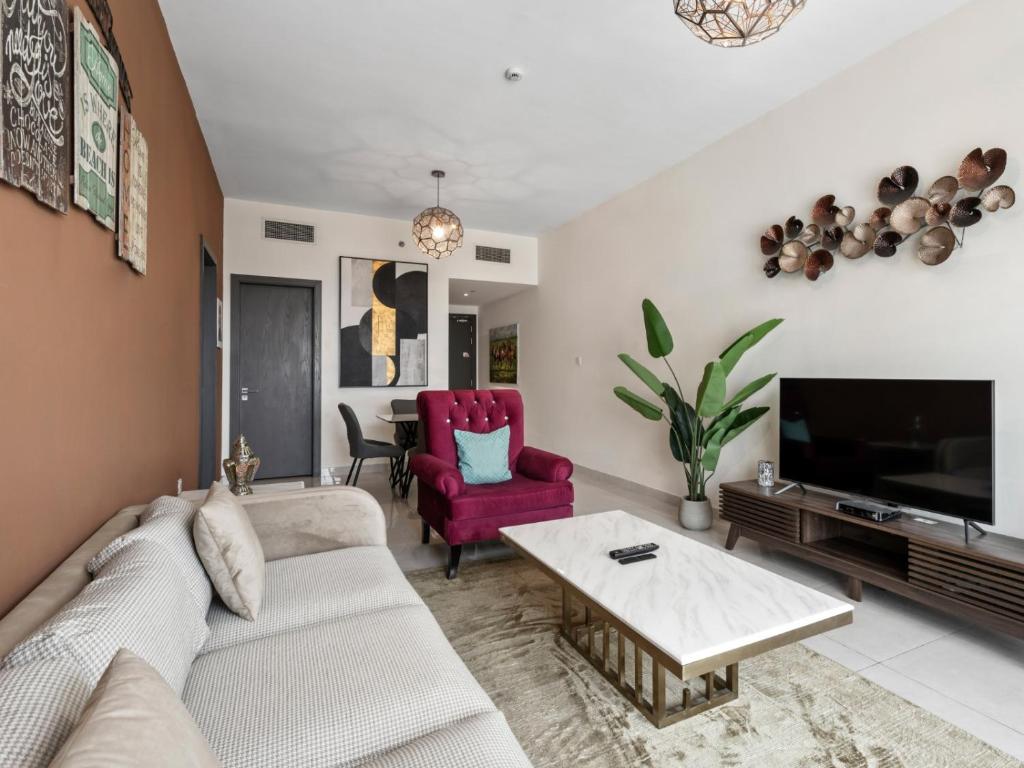 un salon avec un canapé et une télévision dans l'établissement Contemporary and Spacious 1-Bedroom in AG tower - Business Bay, à Dubaï
