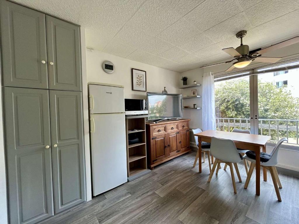 une cuisine avec une table et un réfrigérateur blanc dans l'établissement Studio 3 personnes - Cap d'Agde avec parking privatif - FR-1-249-440, au Cap d'Agde