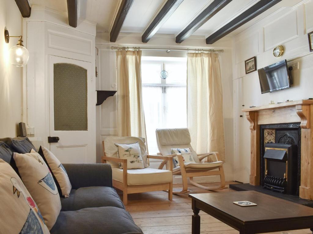 a living room with a couch and a fireplace at Cobblestones in Whitby