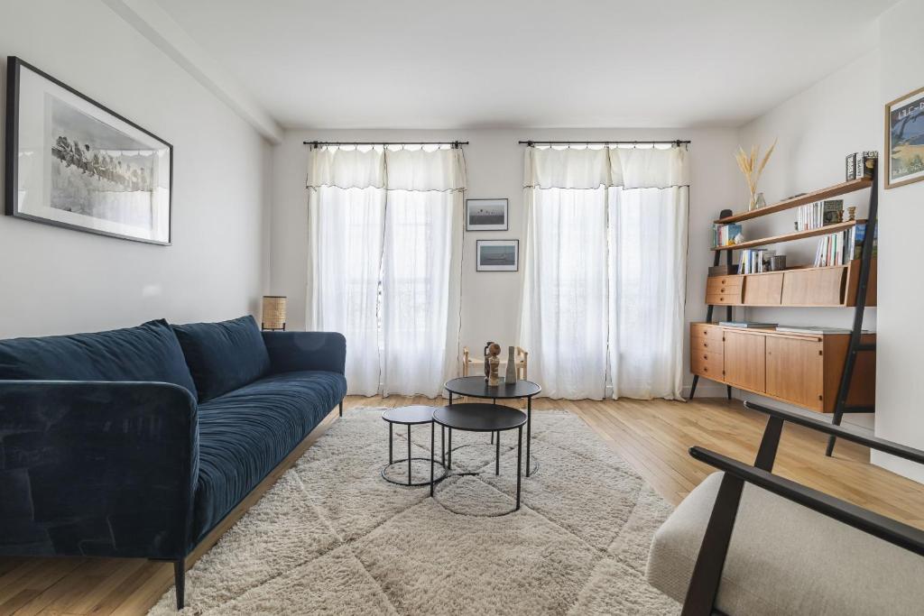 un salon avec un canapé bleu et une table dans l'établissement Vita, à Paris