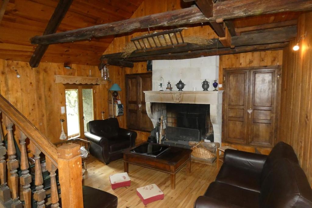 un salon avec cheminée et meubles en cuir dans l'établissement Chalet de Saint Dalmas, à Saint-Dalmas-le-Selvage