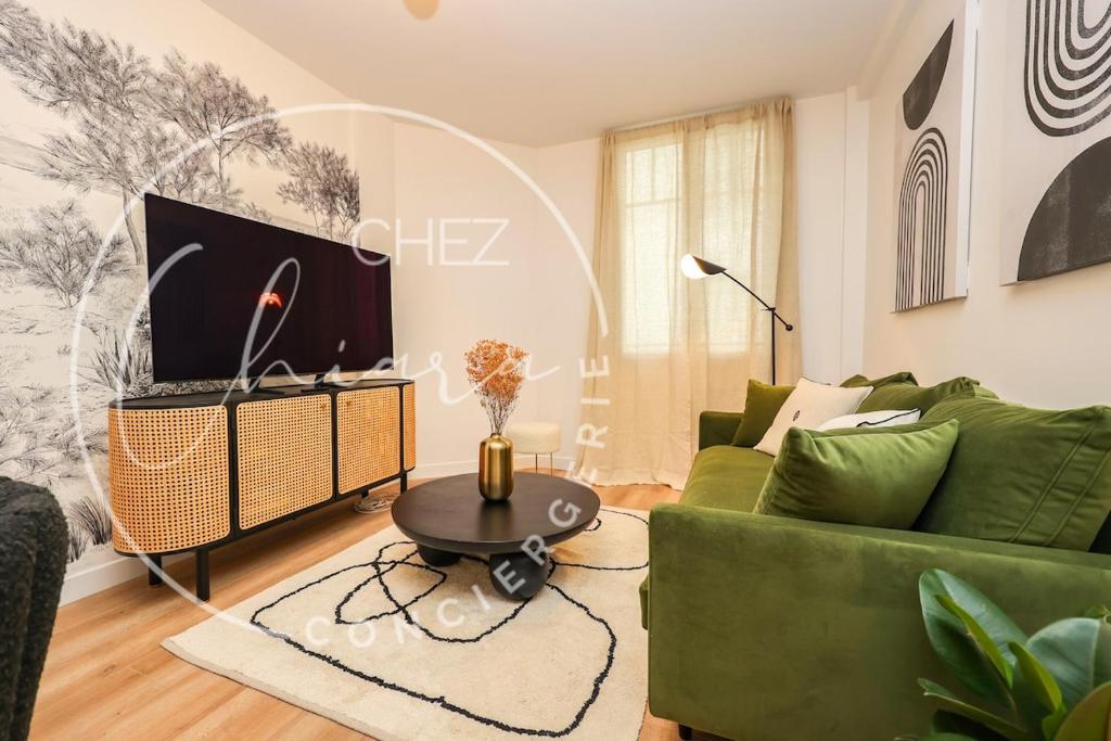 un salon avec un canapé vert et une table dans l'établissement EIFFEL TOWER Charming and Modern Flat, à Paris